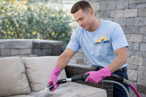 Technician performing professional steam carpet cleaning in a South Florida home